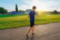 Teen boy running along the stadium track, a soccer field with green grass - concept of sports and health Royalty Free Stock Photo