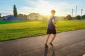 Teen boy running along the stadium track, a soccer field with green grass - concept of sports and health Royalty Free Stock Photo