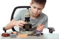 Teen boy in school laboratory. Researcher working with microscope