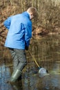 Teen boy scooping up pond life with small net Royalty Free Stock Photo