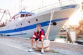 Happy teen boy in sea port dreaming about long journeys against big ship