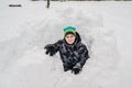 Teen boy sitting in homemade snow fort