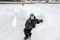 Teen boy sitting in homemade snow fort