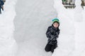 Teen boy sitting in homemade snow fort