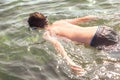 Teen boy in the snorkeling mask dives in the wave of sea in the tropical resorts. Concept of summer vacation. Royalty Free Stock Photo