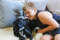 Teen boy snuggling on couch with pet dog. Man's best friend. Black kelpie x labrador breed