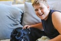 Teen boy snuggling on couch with pet dog. Man's best friend. Black kelpie x labrador breed