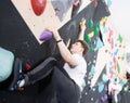 Teen guy practicing rock climbing on climbing wall Royalty Free Stock Photo