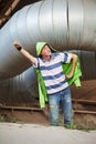 Teen boy superhero under industrial pipeline