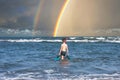 Teen boy in the swim flippers snorkeling mask and tude in the sea wave on the rainbow background