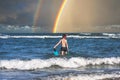 Teen boy in the swim flippers snorkeling mask and tude in the sea wave on the rainbow background