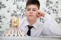 teen boy at table with cake for his fourteenth birthday