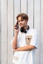 teen boy talking on mobile phone outdoor on a white wooden background Royalty Free Stock Photo