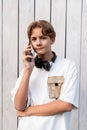 teen boy talking on mobile phone outdoor on a white wooden background Royalty Free Stock Photo