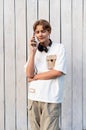 teen boy talking on mobile phone outdoor on a white wooden background Royalty Free Stock Photo