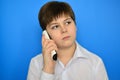 Teen boy talking by radiotelephony on a blue background Royalty Free Stock Photo