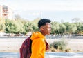 Teen boy walks in yellow jacket and red backpack through the city Royalty Free Stock Photo
