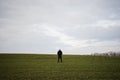 Teen boy wearing black jacket and white hat outside, enjoys in the early spring field Royalty Free Stock Photo