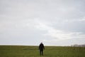 Teen boy wearing black jacket and white hat outside, enjoys in the early spring field Royalty Free Stock Photo