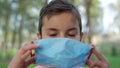 Teen boy wearing medical mask outdoors. Young guy protecting from covid19. Royalty Free Stock Photo