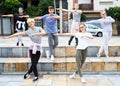 Teen boys and girls dancing modern choreography on city street