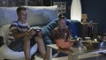 Teen boys playing videogame together on sofa Royalty Free Stock Photo