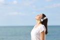 Teen breathing fresh air listening to music on the beach