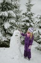 Child, snowman and winter forest Royalty Free Stock Photo