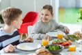 Teen children talking during healthy breakfast in the morning before going to school