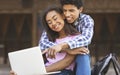 Teen couple browsing internet on laptop booking tickets to cinema