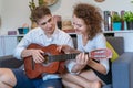 Teen couples are teasing each other during playing guitar