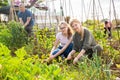 Teen daughter helps mother clean weeds in garden beds