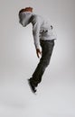 Teen, fashion and jump with energy in studio with kid in streetwear hoodie on grey background. African, child and cool Royalty Free Stock Photo