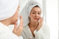 Teen girl with acne problem applying cream near mirror Royalty Free Stock Photo