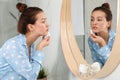 Teen girl with acne problem cleaning her face near mirror Royalty Free Stock Photo