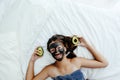 Teen girl applying black clay facial mask with avocado Royalty Free Stock Photo