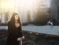 Teen girl in black coat and long brown hair with schooter Royalty Free Stock Photo