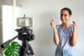 Teen girl blogger influencer recording video blog concept speaking looking at smartphone on tripod at home. Teenager Royalty Free Stock Photo