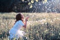 Teen girl blowing seeds from a flower dandelion in spring park Royalty Free Stock Photo