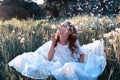 Teen girl blowing seeds from a flower dandelion in spring park Royalty Free Stock Photo