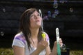 Teen girl blows bubbles