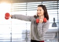 Teen girl boxing with hand barbell