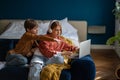 Teen girl and boy brother and sister watching movie together on laptop sitting on couch. Royalty Free Stock Photo