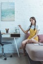 teen girl with braids putting dollar banknote into glass jar