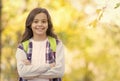 teen girl carry backpack on the way to school. child walk in autumn forest. fall leaves in park. seasonal weather Royalty Free Stock Photo