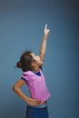 Teen girl child pointing at the sky on gray