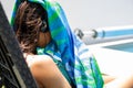 Teen girl covering head from he sun at the pool while listening to music