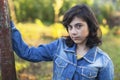 Teen girl in denim jacket portrait outdoors.