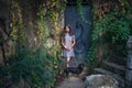 Teen girl in dress with dachshund dog against old metal door with colorful creeper plants around