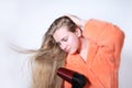 Teen girl drying long wet hair using hairdryer